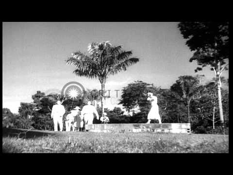 A man and a woman hit balls with golf clubs as others look on in Caracas, Venezue…HD Stock Footage